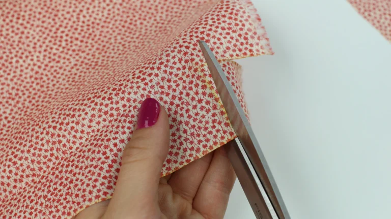 Cutting fabric pieces for zip tabs when making a quilted wash bag.