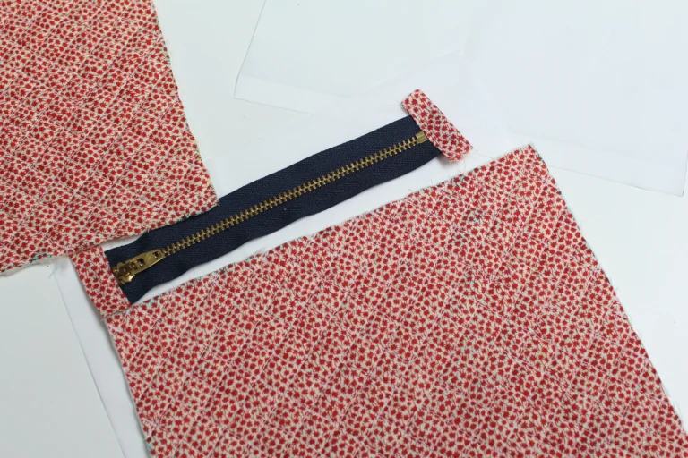 Metal zip with fabric zipper tabs attached, prepared for a quilted wash bag sewing project.