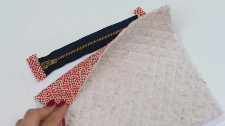 Quilted exterior fabric placed next to a zip with zipper tabs for a quilted wash bag.
