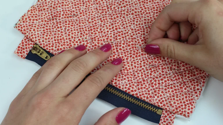 Pinning the quilted wash bag fabric around the zip before sewing.