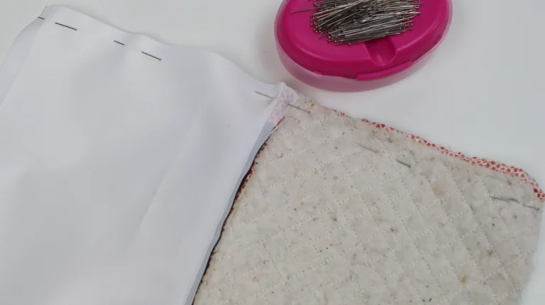 Pinning the lining to the quilted wash bag exterior in preparation for sewing.