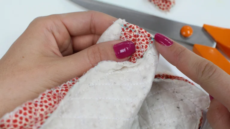 Checking alignment of a boxed corner seam on a quilted wash bag.