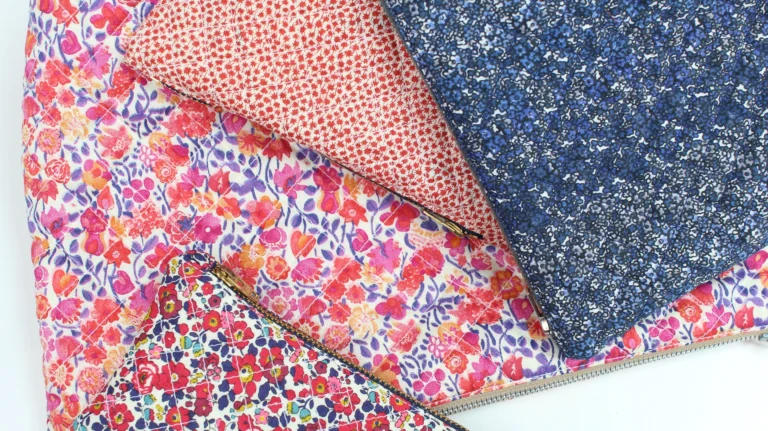 Flat lay of quilted wash bags made from Liberty cotton fabrics in multiple prints.