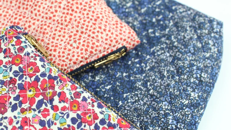 Close-up of quilted wash bags showing metal zips and Liberty cotton fabric details.