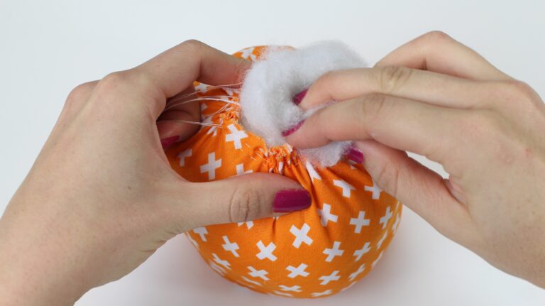 Add stuffing into the top of the pumpkin, whilst closing the gathering stitches