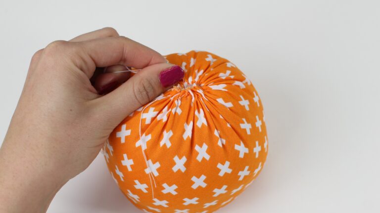 Secure the gathering stitches on the top of the pumpkin