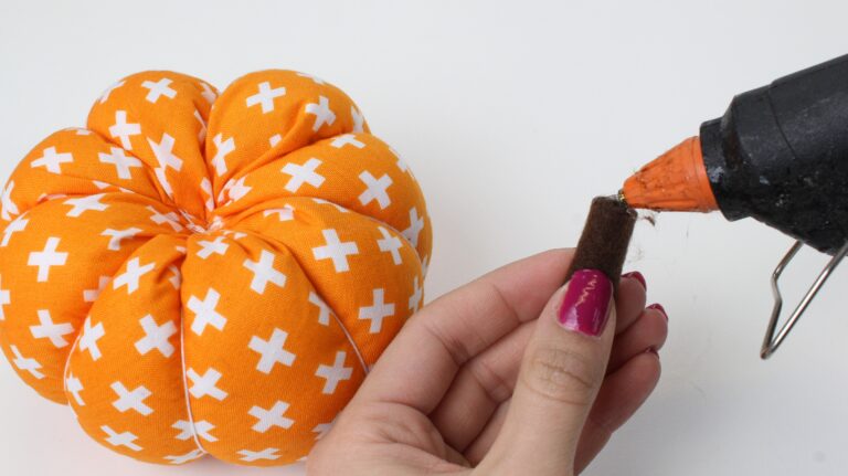 Use hot glue to fix the pumpkin stem to the top of the pumpkin