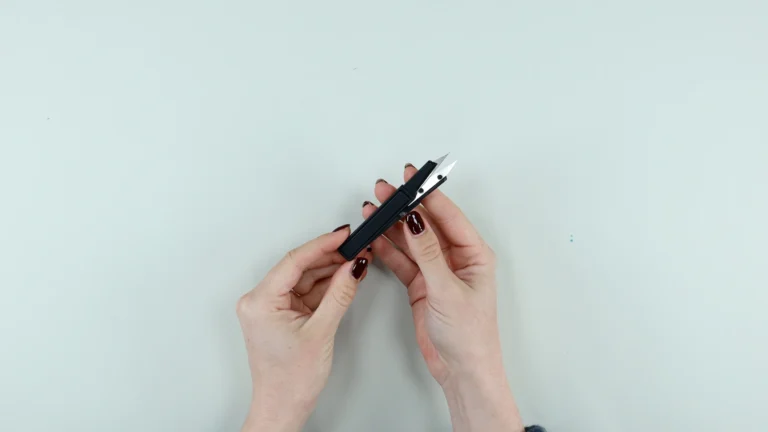Gingher snips held in hands - essential sewing tool for trimming threads and clipping curves