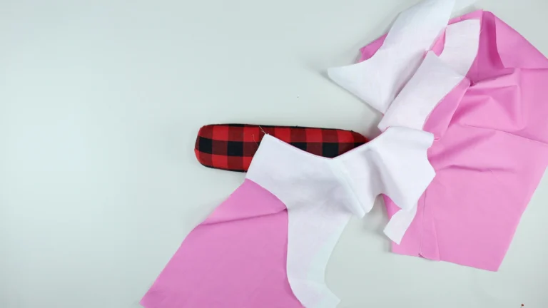 Pressing the understitching of the neckline on a seam roll, between a bodice and all-in-one facing