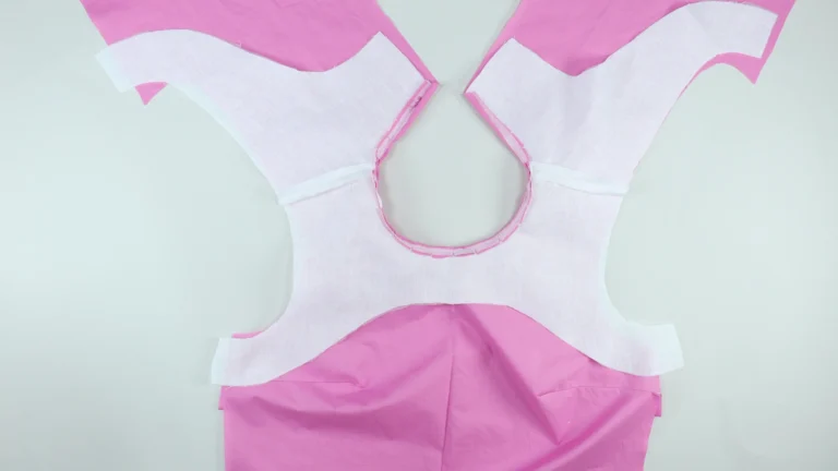 All-in-one facing wrong side facing up, neck sewn, positioning the right side of the bodice and facing together