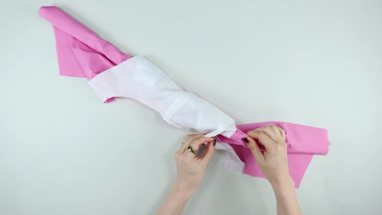 Grab the rolled up fabric in the shoulder, for the second side and pull to turn the garment to the right side, burrito method for all-in-one facing without centre back seam