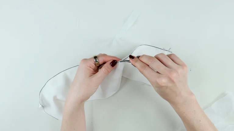 Removing left over tissue paper with tweezers on a silk georgette baby hem