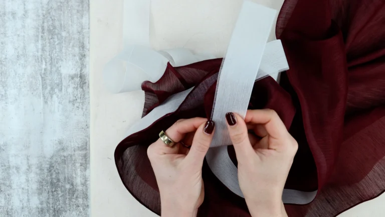 Pulling the Ban-Rol out of a finished baby hem, holding the fabric firmly to avoid distortion
