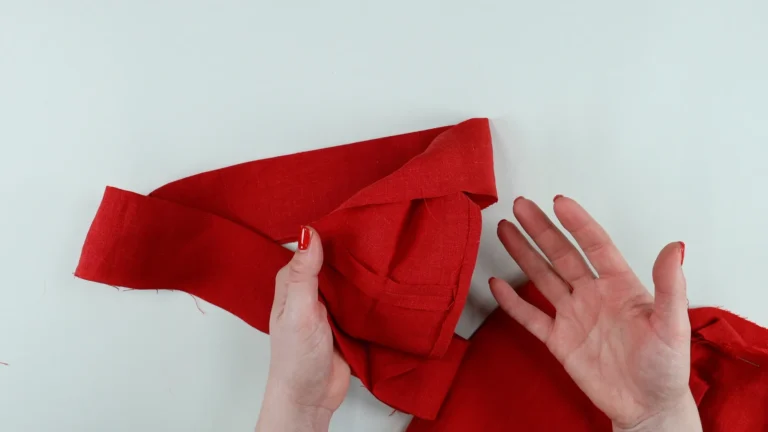 Pressed inside seam allowance of the waistband, towards the inside of the waistband