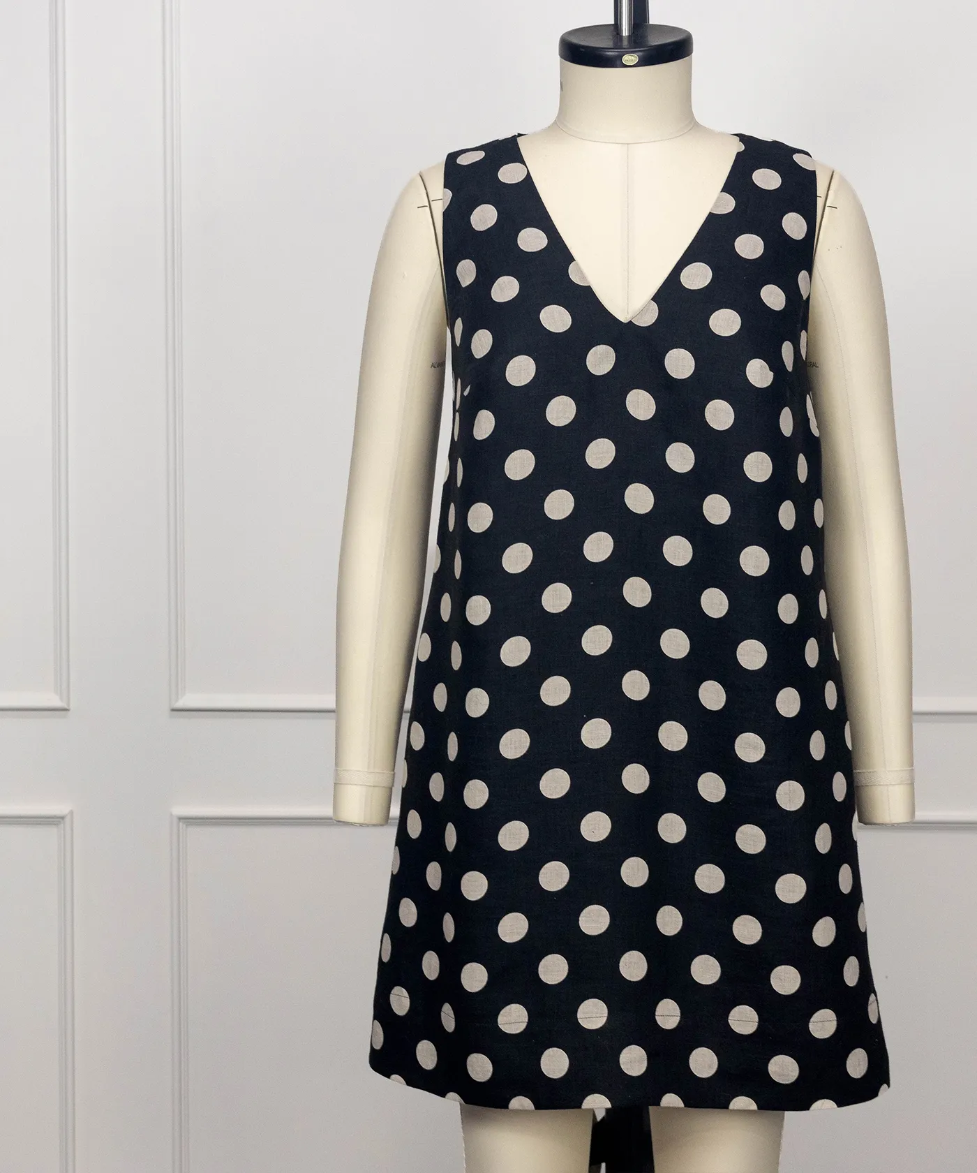 Neve sleeveless V-neck A-line dress in black and cream polka dot linen, short length